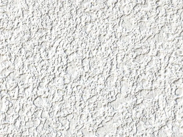 Détail d’une façade recouverte d’un crépi projeté blanc à grain fin