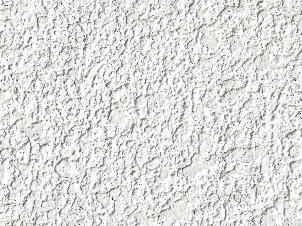 Détail d’une façade recouverte d’un crépi projeté blanc à grain fin