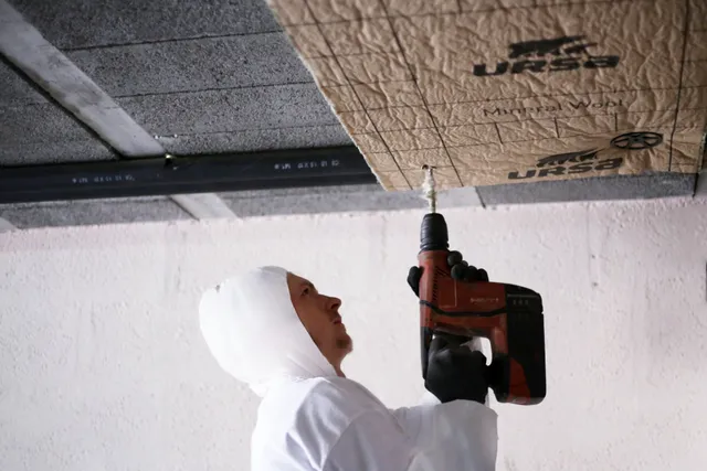Panneaux isolants fixés sous le plafond d’un sous-sol pendant l’isolation d’un plancher bas